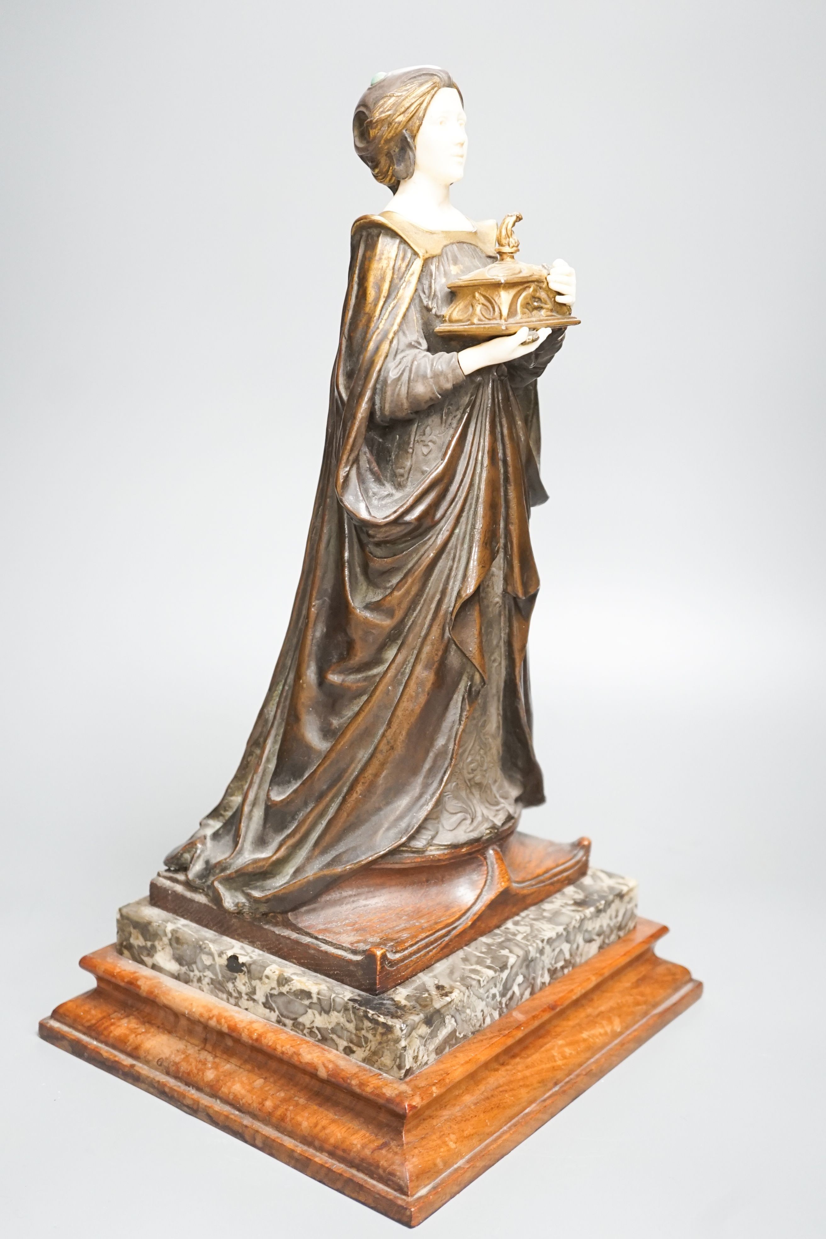 A German Art Nouveau bronze and ivory figure of Pandora, with inset carved ivory head and hands on polished stone and cut wood base, signed F. Jahn, 41cm high